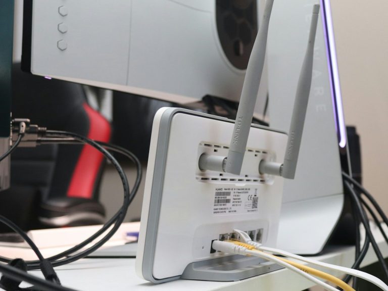 A router with antennas and multiple cables connected at the back.